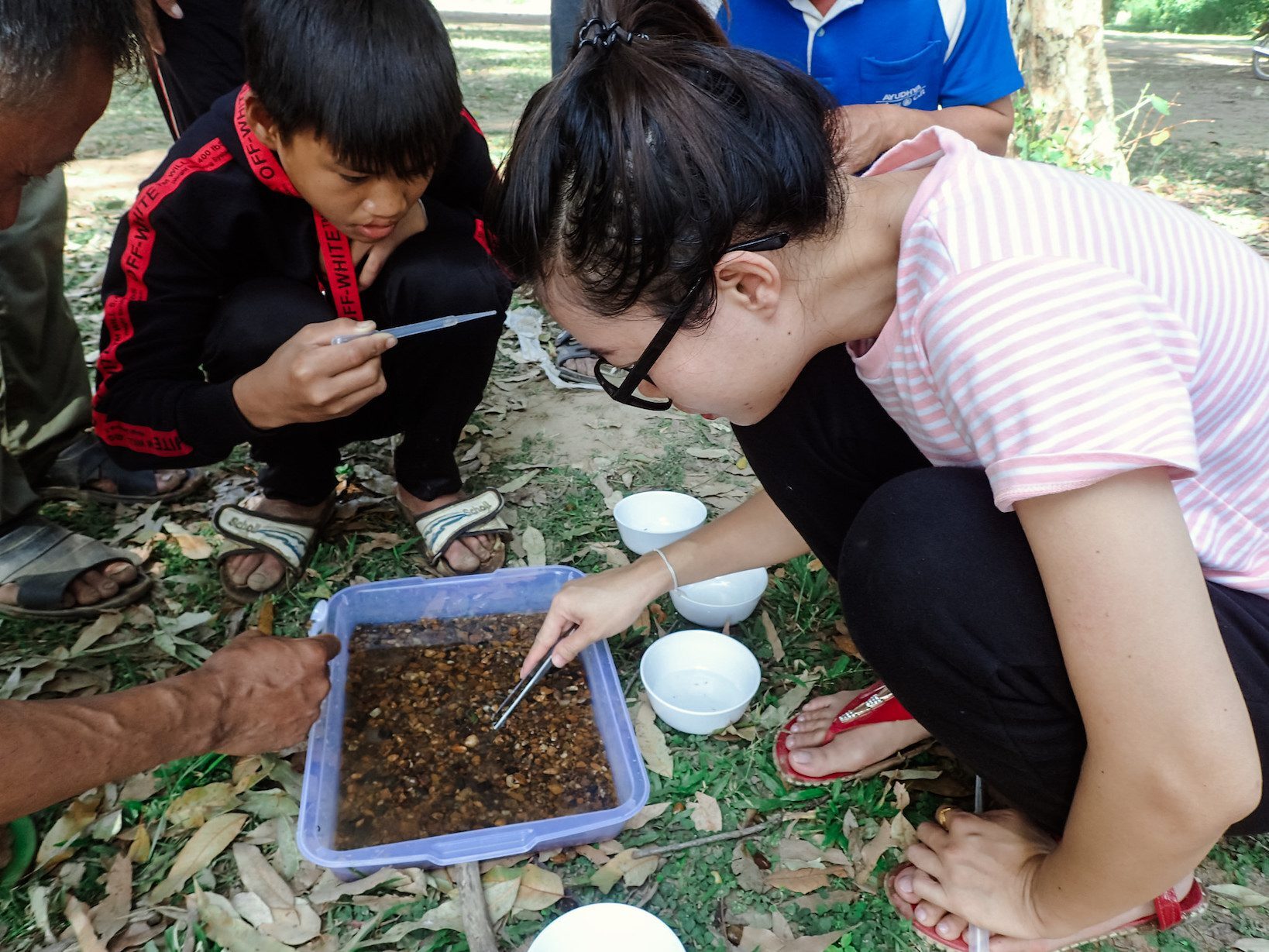 Teacher doing water quality monitoring with students