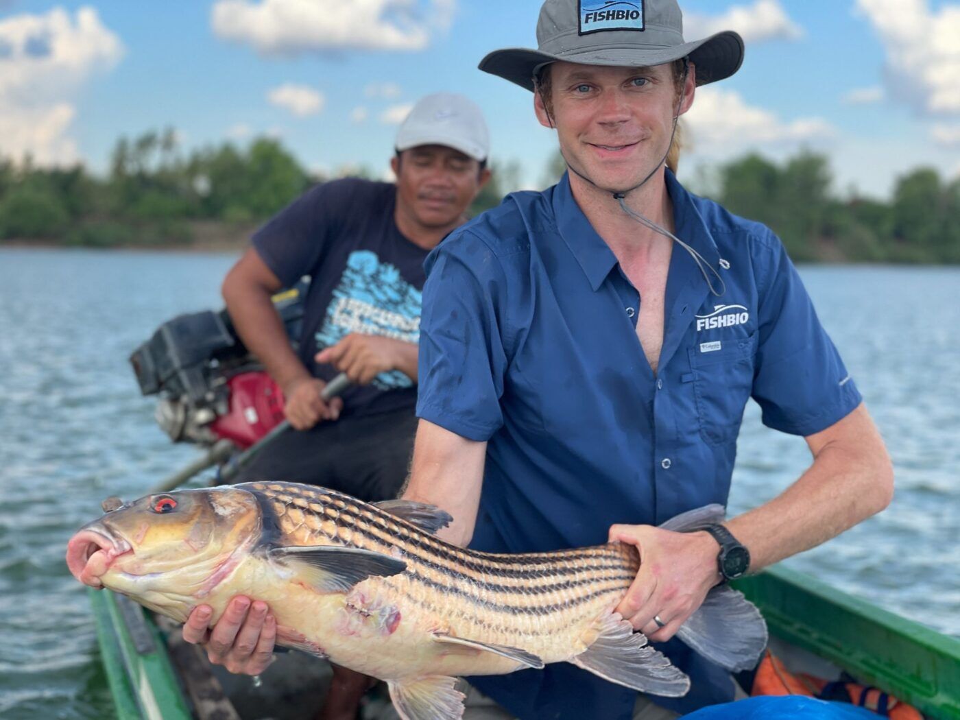 Man holding a fish in a boat